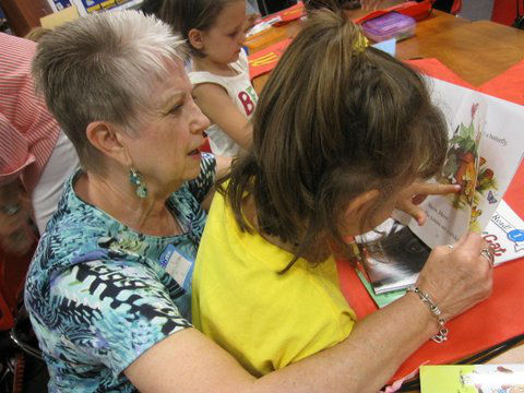 PWC member Gloria Tucker reads with a Malakoff student who just received a new book. (COURTESY PHOTO)