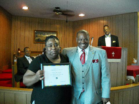 Sis. Nettie Bea Anderson receives her award from Rev. I.B. Wells, Jr., with Rev. Ricky Barnes and Rev. Ray c. Emanuel looking on.
