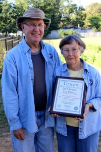 Bill and Marie Hancock show off the first-place award given to the Henderson County Master Gardener Association by the statewide chapter. The award was in recognition of the local chapter’s work with the South Athens Children’s Garden. (Toni Garrard Clay/AISD)