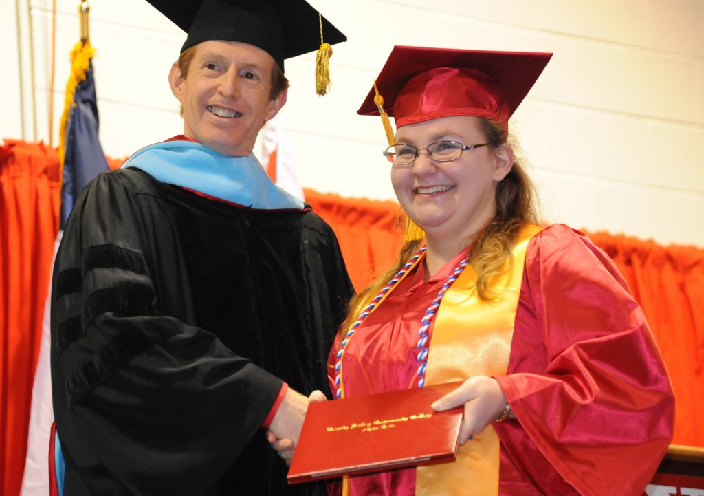 Catherine R. Hopkins (right) receives her diploma from TVCC President Dr. Glendon Forgey during fall commencement ceremonies at Trinity Valley Community College Thursday evening. Hopkins, who served in the U.S. Army, and other graduates currently serving or who have served in the military wore red, white and blue cords to signify their service.