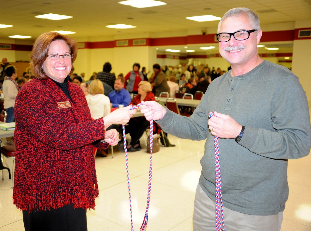 TVCC Vice President of Institutional Advancement Mary Nicholson (left) presents a red, white and blue military cord to faculty member Marshall Reeves during spring in-service Wednesday. Reeves and his wife, Iris (not pictured), each received a cord in recognition of their military service.