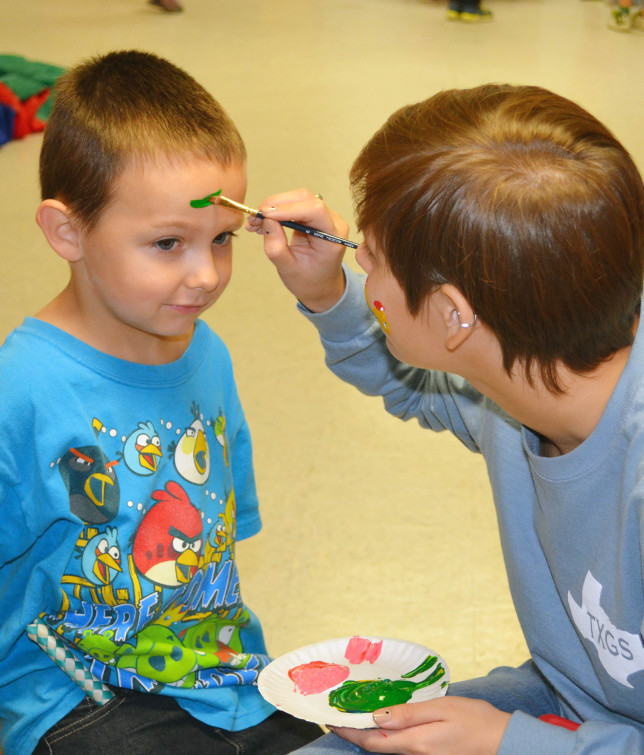 Hayden Tooley having his face painted by Riley Lenz.