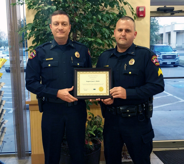 Athens Police Chief Buddy Hill, left, presents the department's Life Saving Award to Sergeant Jason Brosher Monday night.